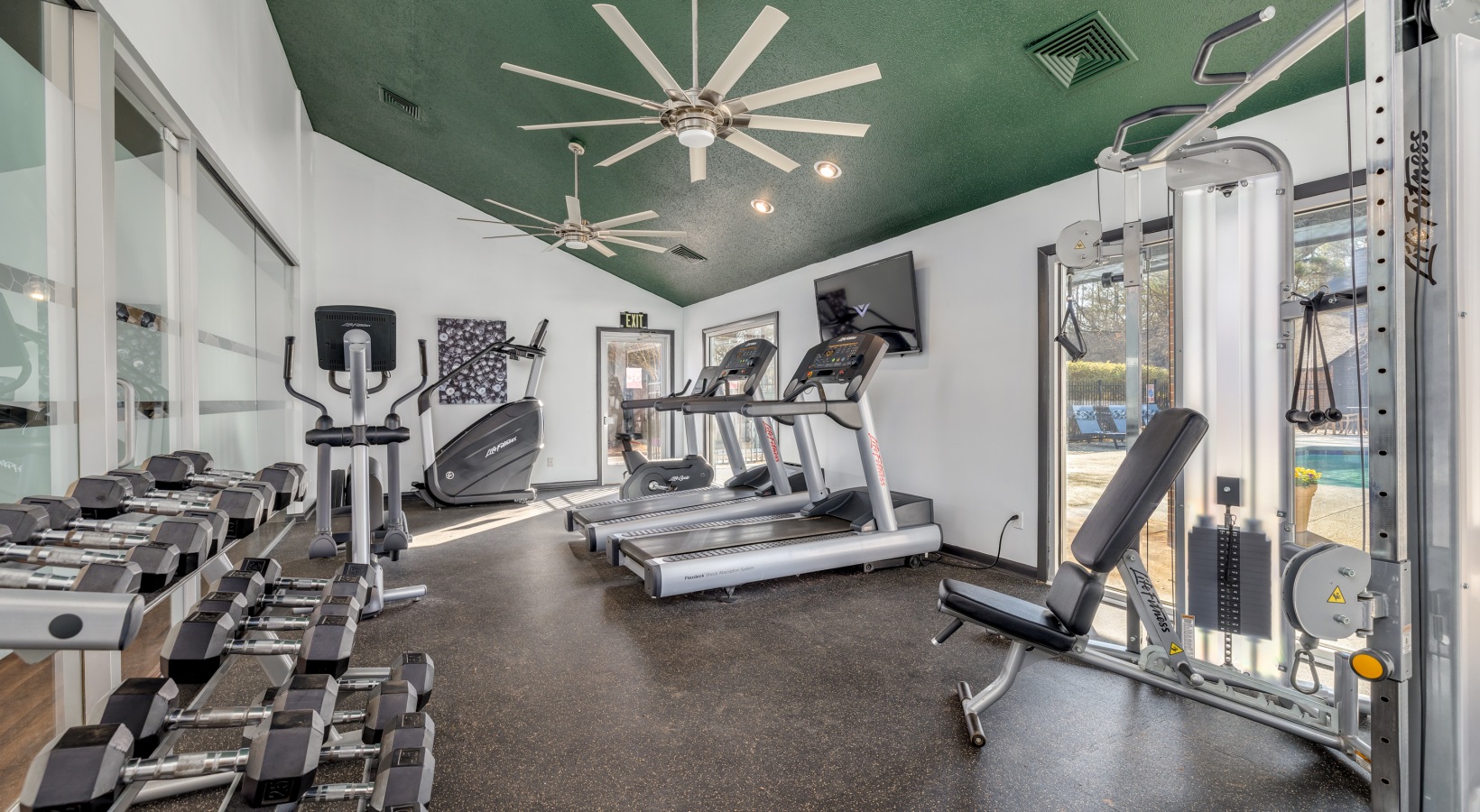 a gym room with exercise equipment and ceiling fans at The  Quinn on Ravenglass