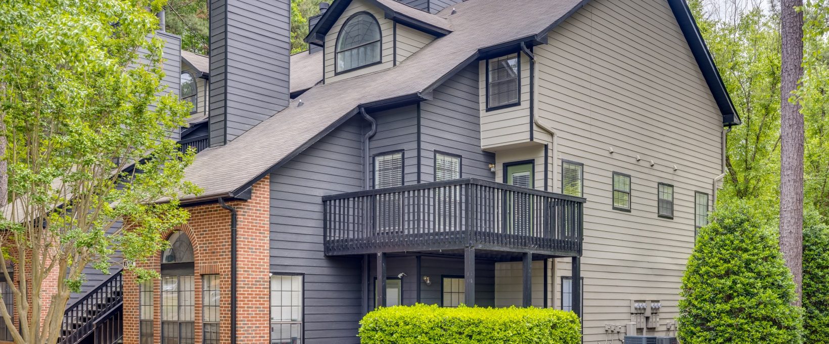 a two story home with a balcony and a deck at The  Quinn on Ravenglass