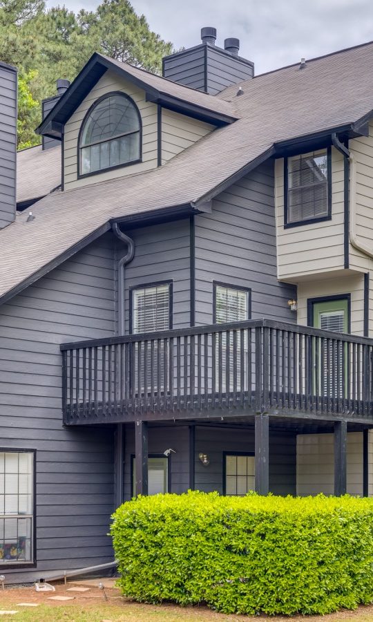 a two story home with a balcony and a deck at The  Quinn on Ravenglass