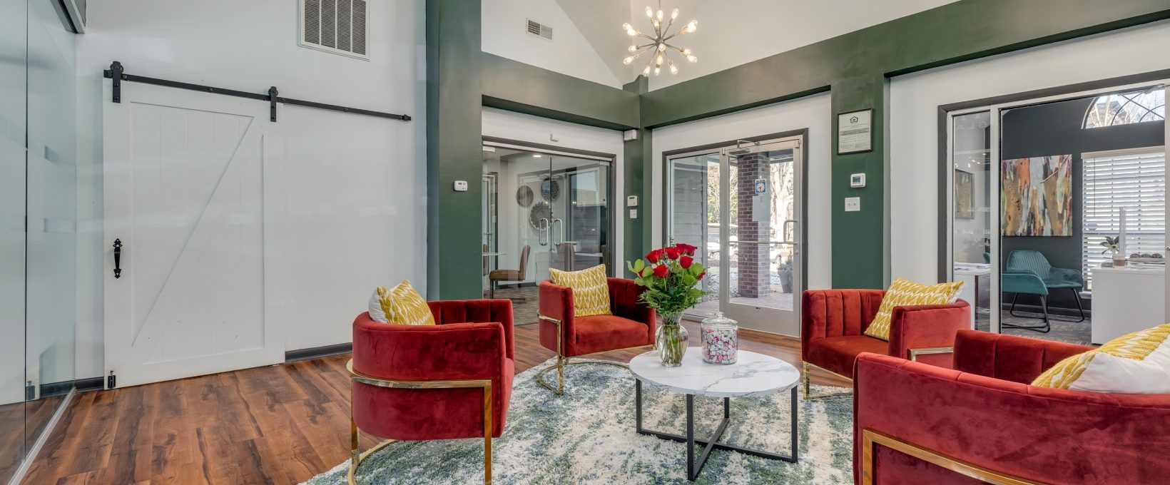 the living room has red chairs and a glass door at The Quinn on Ravenglass