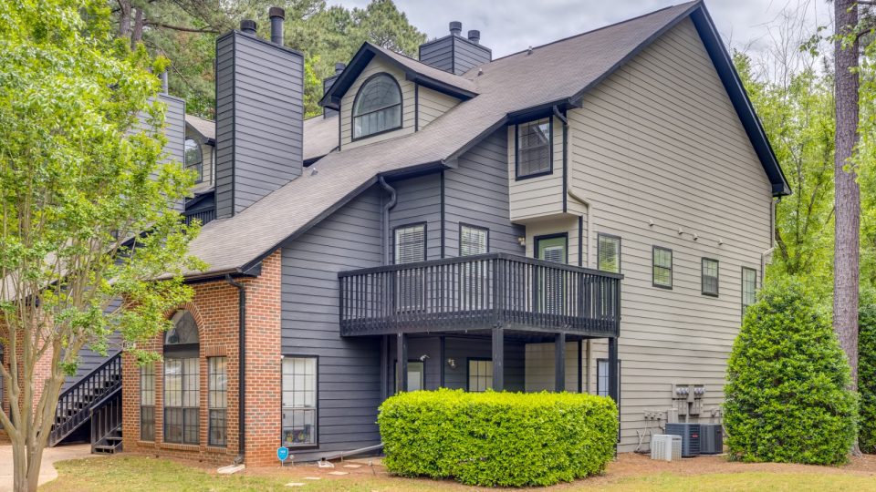 a two story home with a balcony and a deck at The Quinn on Ravenglass